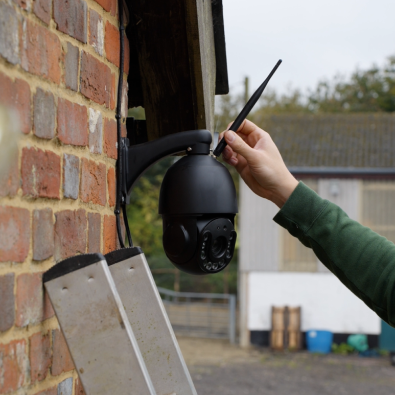 Person installing a security camera on a brick wall with 4G SIM Card.